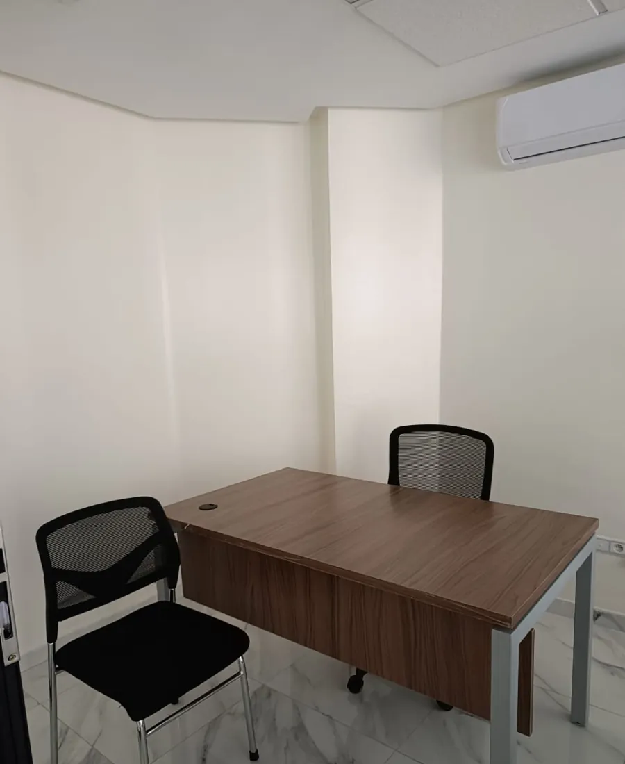 Bureau 1 : bureau individuel climatisé avec table en bois, fauteuil et chaise visiteur